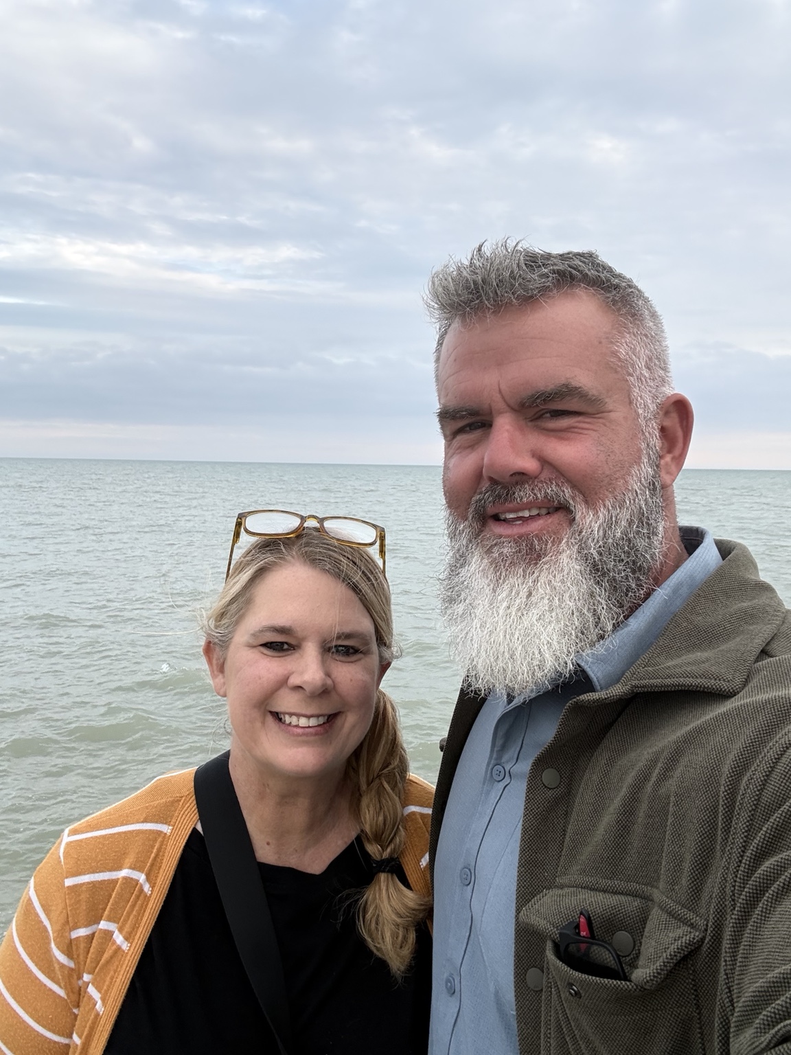 Luke and Megan smiling together with the lake behind them